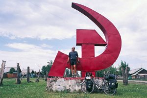 Foto zu Diashow "Der Sonne entgegen - Wladiwostok", Reiseimpressionen von Thomas Meixner. Zu sehen sind der Autor mit Fahrrad vor Hammer und Sichel in Russland.